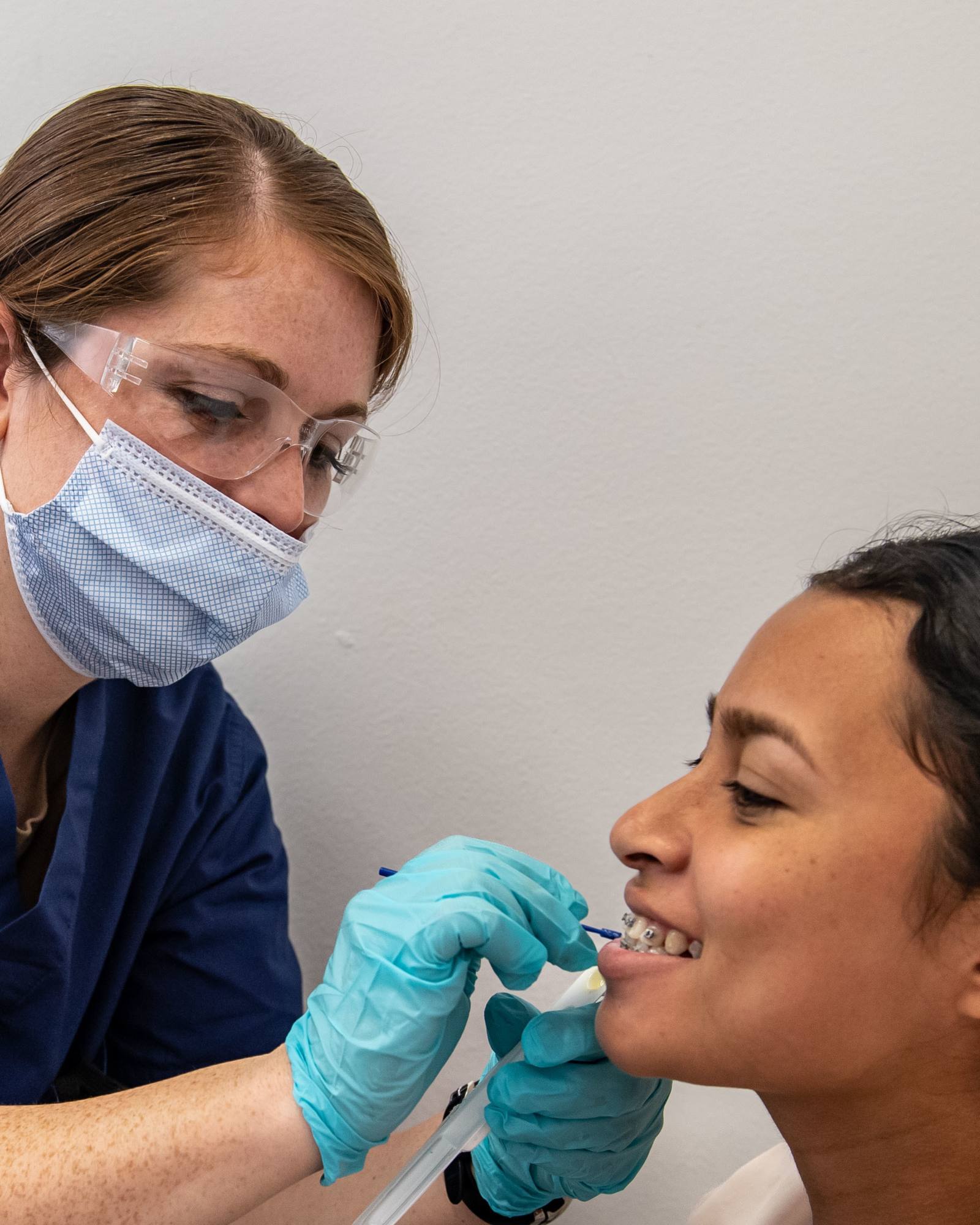 A dentist chatting with a smiling patient in a bright treatment room