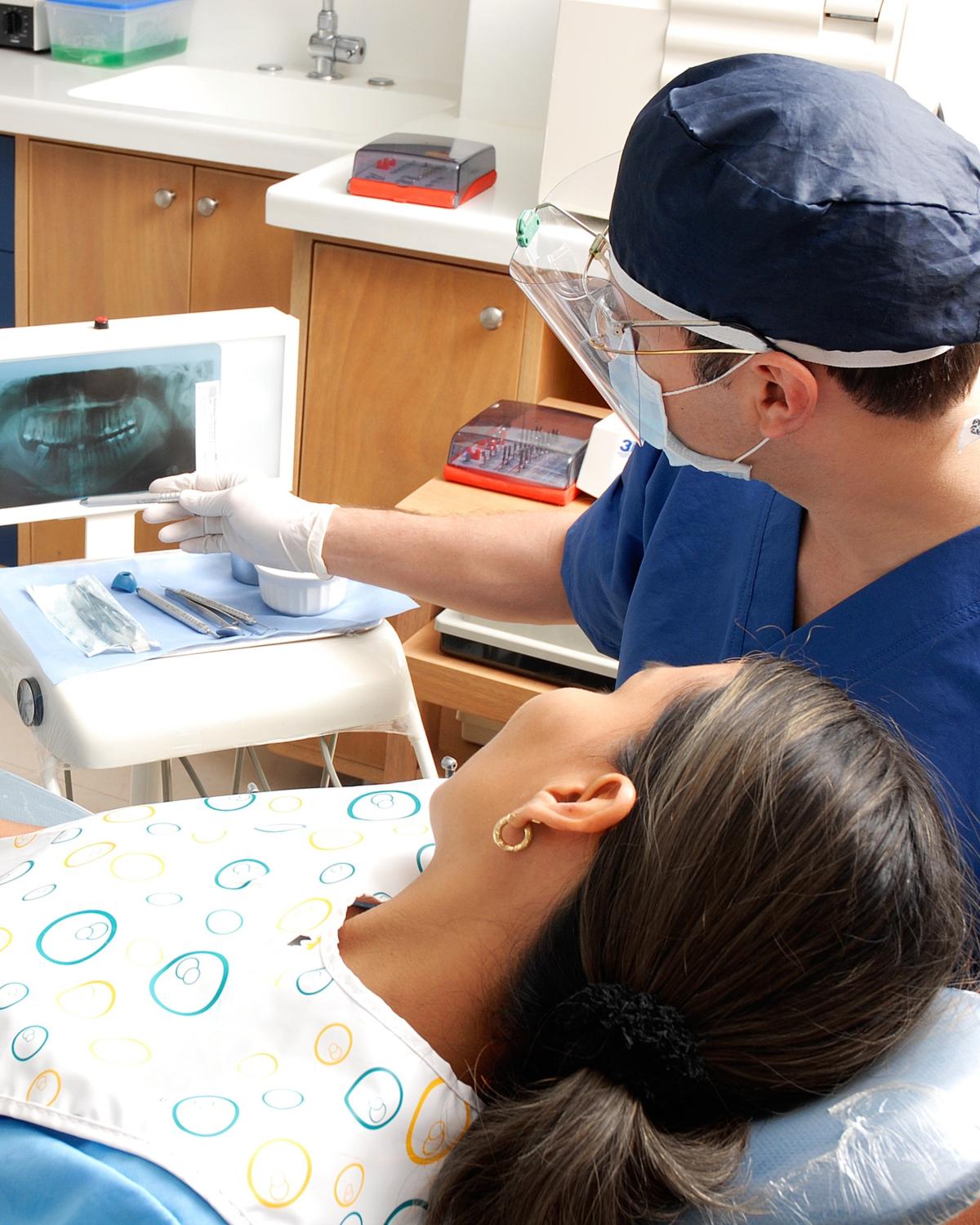 A dentist talking a patient through their treatment